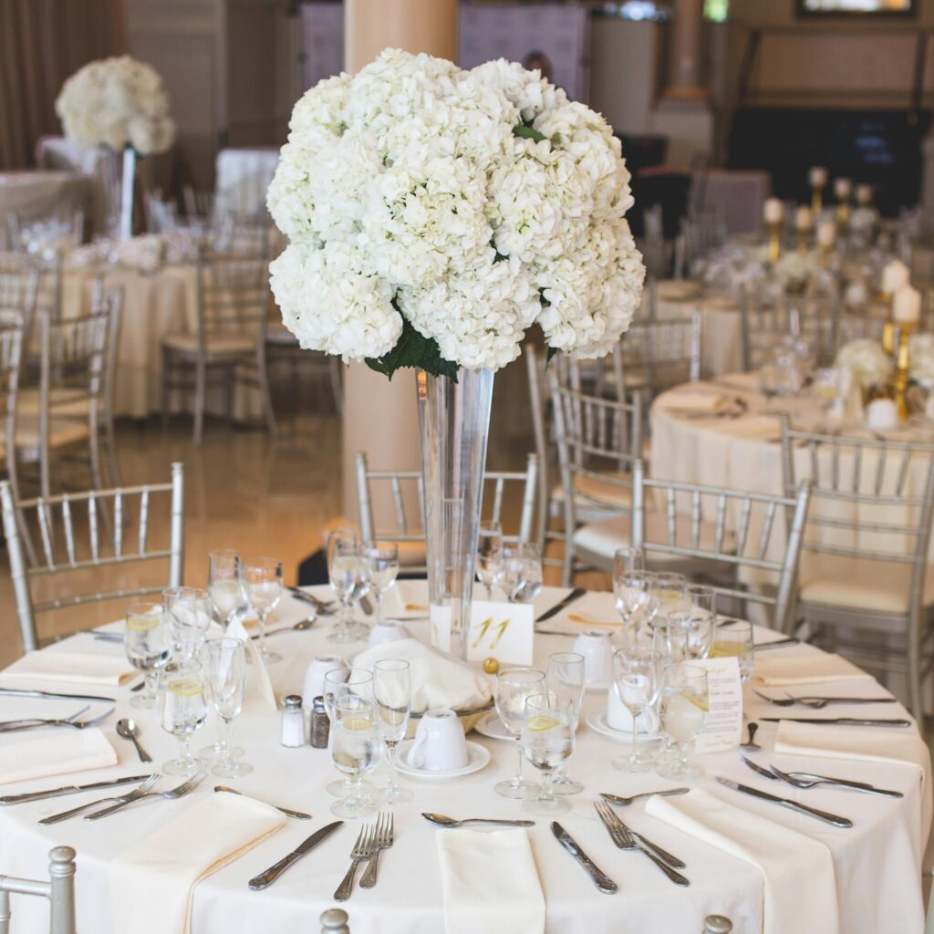 Beautifully decorated wedding reception table with elegant floral centerpiece and silverware.