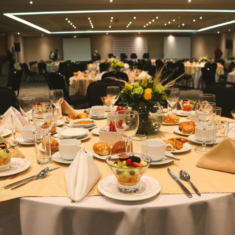 Luxurious banquet table with arranged dishes and floral centerpiece at a formal event setting.